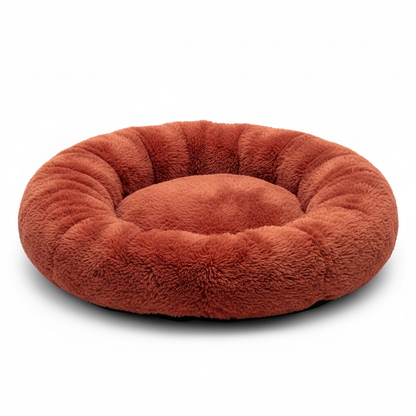 Red donut shaped pet bed on white background